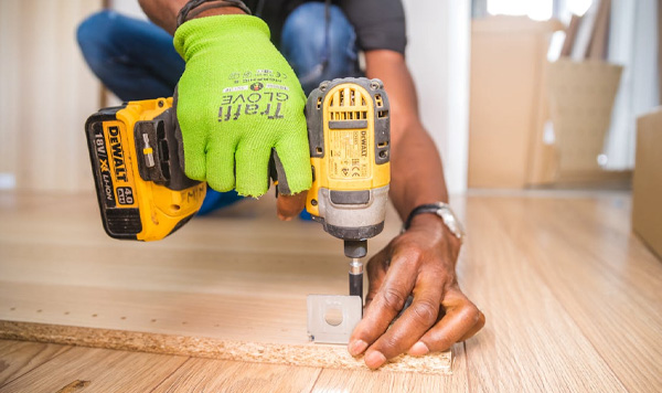 Image Of Contractor Drilling The Wood In The Floor