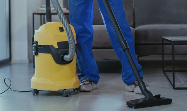Image Of Employee Vacuuming The Floor